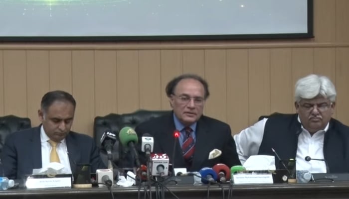 Finance Minister Muhammad Aurangzeb speaks (centre) address a press conference in Islamabad, August 19, 2026. — Screengrab via YouTube/Geo News