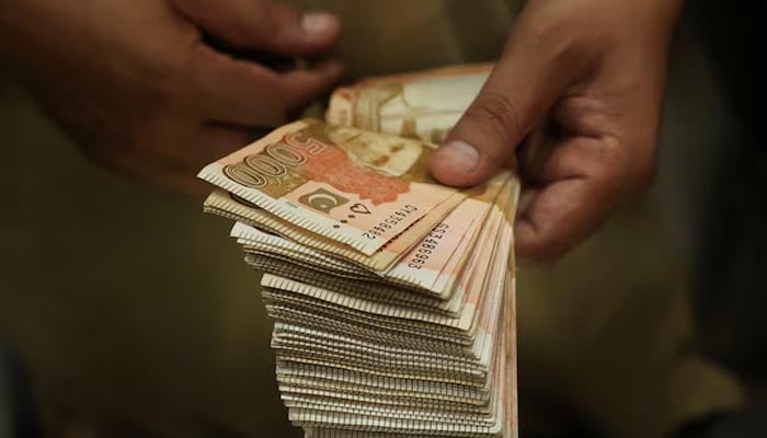 A trader counts Pakistani rupee notes at a currency exchange booth in Peshawar, July 29,2025. — Reuters