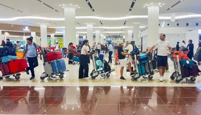 People queue at the check-in counter at the Dubai International Airport, in Dubai, United Arab Emirates, April 17, 2024. — Reuters