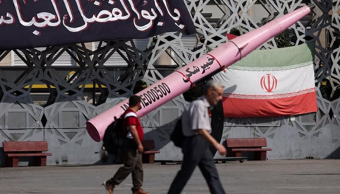 People walk next to a symbolic mockup of an Iranian missile and an Iranian flag at Imam Hussein Square in Tehran, Iran, July 12, 2026. — Reuters