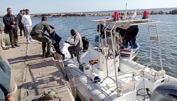 A Tunisian national coast guard helps a migrant child get off a rescue boat in Jbeniana, Safx, Tunisia, April 23, 2022, in this screen grab taken from a handout video taken April 23, 2022. — Reuters