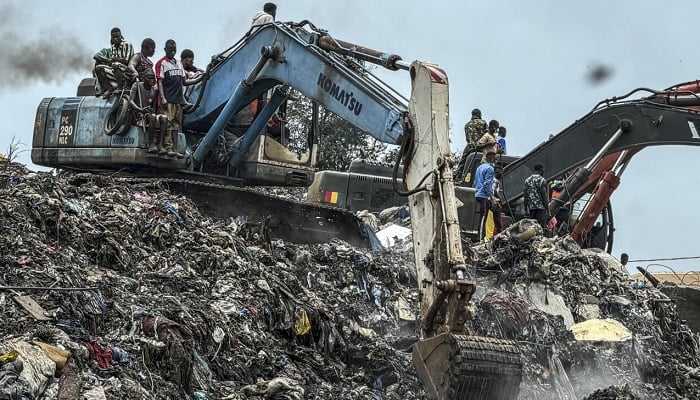 Residents and rescue workers use an excavator to search for bodies after a landslide struck the Dar-es-Salaam dumpsite in Conakry, Guinea, on Sunday, August 23, 2026.— Reuters