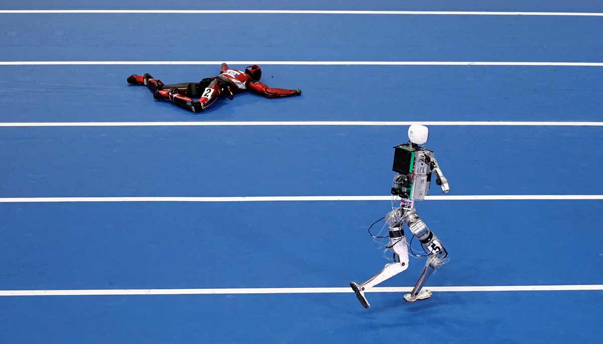 A humanoid robot runs past a fallen humanoid robot during a 100m large-sized group preliminary race, following the opening ceremony of the 2026 World Humanoid Robot Games, at the National Speed Skating Oval, in Beijing, China August 22.— Reuters