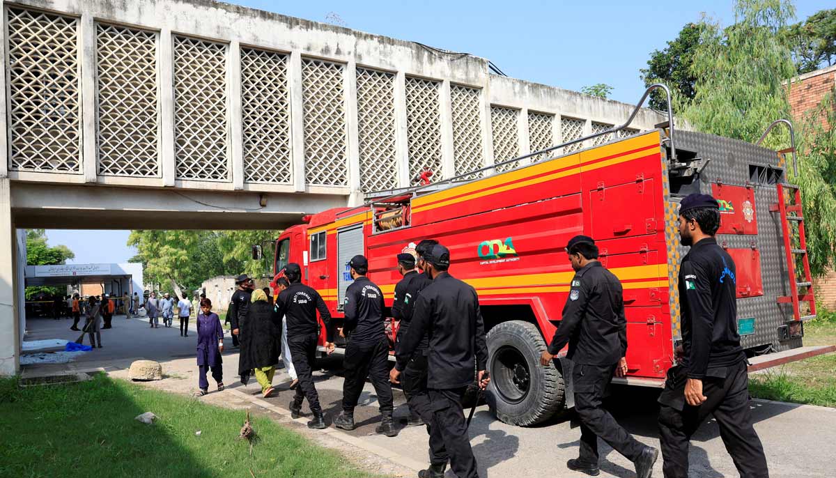Members of Anti-Terrorist Squad move past a fire engine following a deadly fire at the Pakistan Institute of Medical Sciences hospital in Islamabad, August 26, 2026.— Reuters