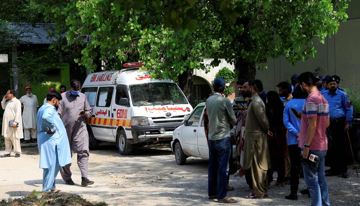 Family members and police officers stand outside a mortuary following a deadly fire at the Pakistan Institute of Medical Sciences hospital in Islamabad, August 26, 2026.— Reuters