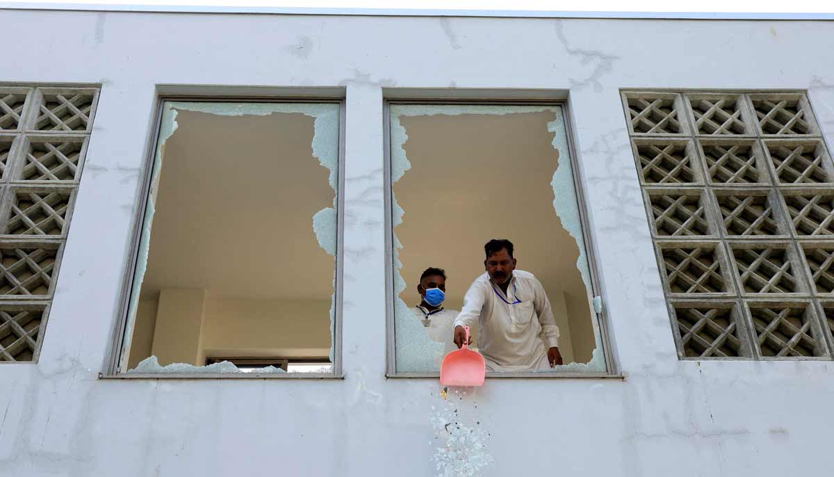 A worker removes broken pieces of a glass window after a fire broke out at the Pakistan Institute of Medical Sciences hospital in Islamabad, August 26, 2026.— Reuters