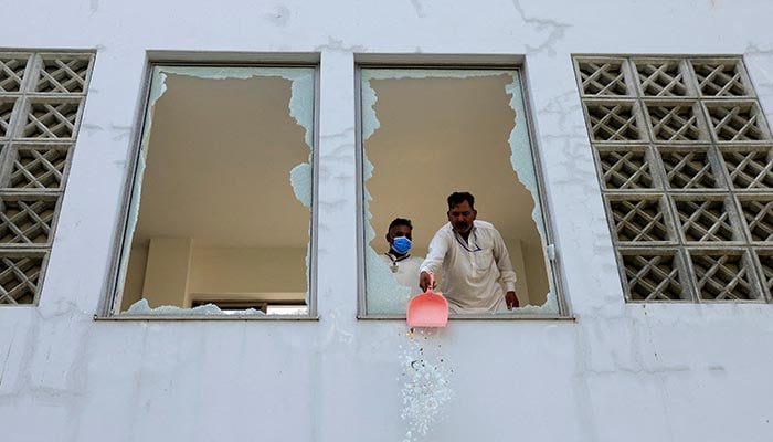 A worker removes broken pieces of a glass window after a fire broke out at the Pakistan Institute of Medical Sciences (Pims) hospital in Islamabad, August 26, 2026. — Reuters