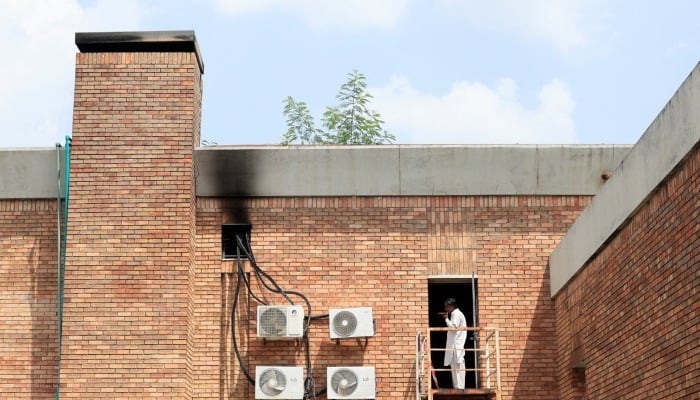 A man speaks on his mobile phone at the intensive care unit building with smoke marks, a day after a deadly fire at the Pakistan Institute of Medical Sciences (Pims) hospital in Islamabad, on August 27, 2026. — Reuters