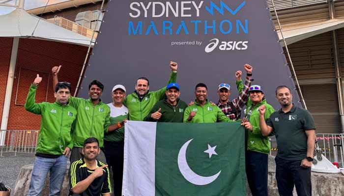 Pakistani runners hold national flag during Sydney marathon in a group picture. — Reporter