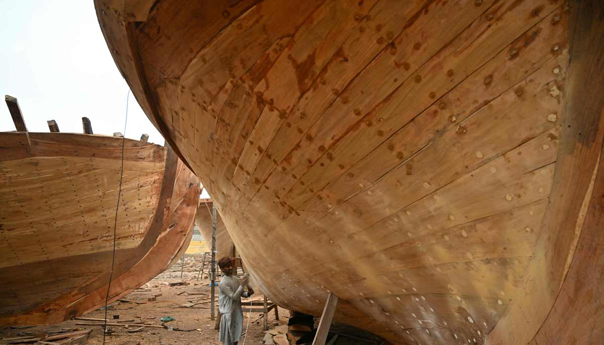 Craftsman Muhammad Asif building a traditional wooden boat at a yard in Ibrahim Hyderi in Karachi.— AFP