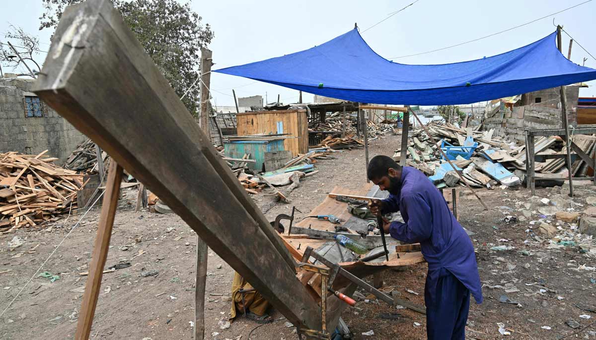 A worker building a traditional wooden boat at a yard in Ibrahim Hyderi.— AFP
