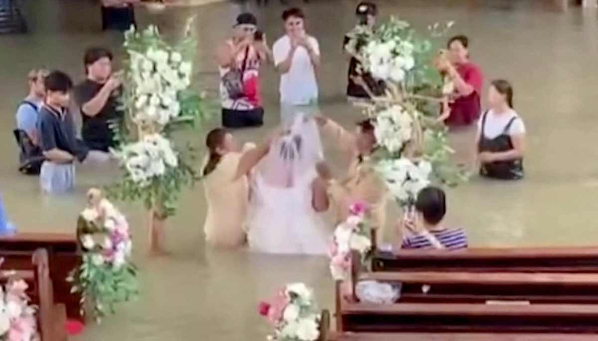 The bride Lhiane Galang walking down the aisle at the St John the Baptist Parish church during their wedding ceremony in a flooded church in Hagonoy town. — AFP