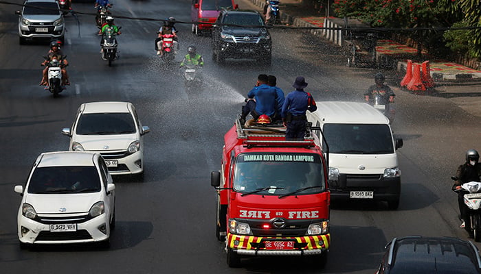 Firefighters spray water to clear volcanic ash following the Mount Anak Krakatau volcano eruption, in Bandar Lampung, Lampung province, Indonesia, September 6, 2026. — Reuters